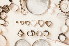 Empty food baking table tins with pastry brush heart cookie cutter tools baking utensils flourish food overhead